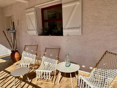 a patio with two tables and chairs and a window at Villa de charme Porto-Vecchio, Plage à 10 min in San-Gavino-di-Carbini