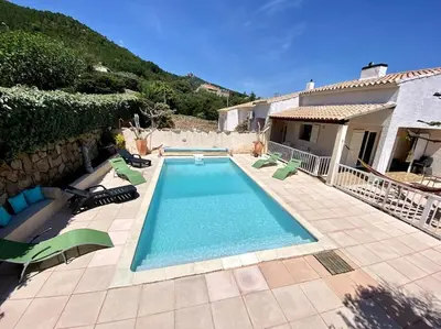 a swimming pool with chairs and a house at Villa de charme Porto-Vecchio, Plage à 10 min in San-Gavino-di-Carbini
