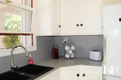 a kitchen with white cabinets and a sink at Villa de charme Porto-Vecchio, Plage à 10 min in San-Gavino-di-Carbini