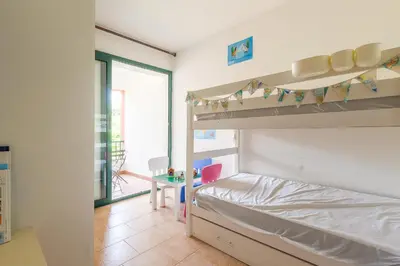 a bedroom with a bunk bed and a desk at La Marine de Bravone in Linguizzetta