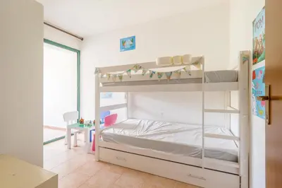 a bedroom with a bunk bed and a desk at La Marine de Bravone in Linguizzetta
