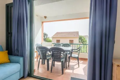a dining room with a table and chairs on a balcony at La Marine de Bravone in Linguizzetta