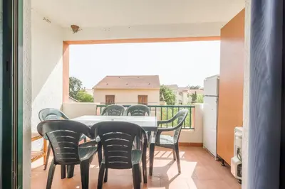 a dining room with a table and chairs on a balcony at La Marine de Bravone in Linguizzetta