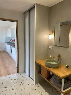 a bathroom with a green sink and a kitchen at T2 très bien équipé vue mer et au calme in Ajaccio