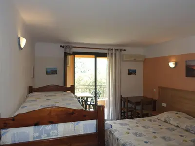 a bedroom with two beds and a balcony at Studio Residence Cabanaccia Studio 38m² by Interhome in Serriera