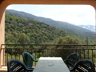 a table and chairs on a balcony with a mountain view at Studio Residence Cabanaccia Studio 38m² by Interhome in Serriera