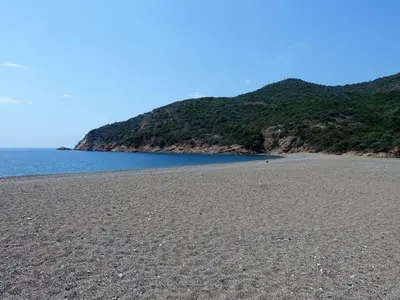 a rocky beach with a mountain in the background at Studio Residence Cabanaccia Studio 38m² by Interhome in Serriera