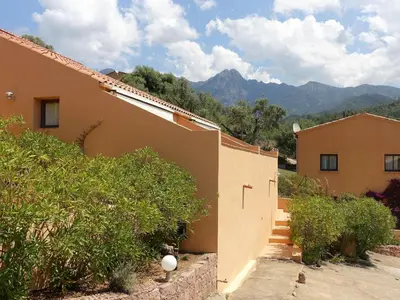 a house with a staircase next to a building at Studio Residence Cabanaccia Studio 35m² by Interhome in Serriera