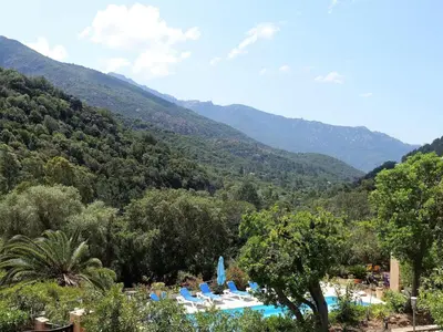 a view of a resort with mountains in the background at Studio Residence Cabanaccia Studio 35m² by Interhome in Serriera