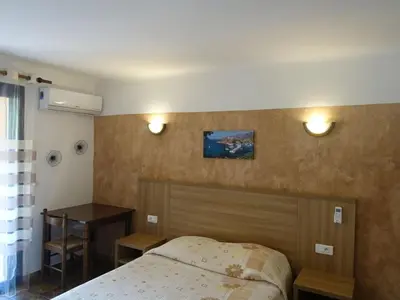 a bedroom with a bed and a table and a desk at Studio Residence Cabanaccia Studio 35m² by Interhome in Serriera