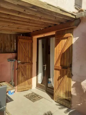 a pair of wooden doors on a house at Petite maison in Lecci