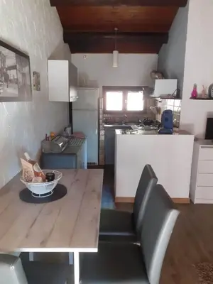 a kitchen with a wooden table and a dining room at Petite maison in Lecci
