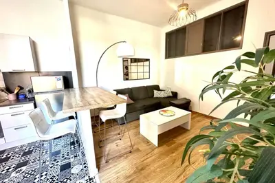 a living room with a couch and a table at Spacious cocoon close to the beach in Ajaccio
