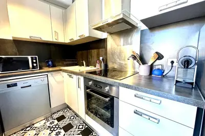a kitchen with a wooden table in a room at Spacious cocoon close to the beach in Ajaccio