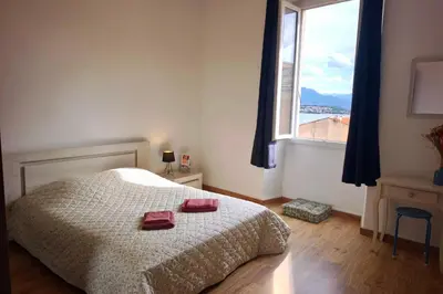 a small bedroom with a bed with a blue and white sheets at Spacious cocoon close to the beach in Ajaccio