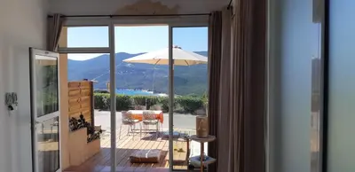 a room with a view of a patio with an umbrella at Mini Villa - Vue mer in Serra-di-Ferro