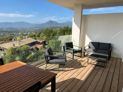 a balcony with chairs and a table and a view at LOCA VACANCES in Porticcio