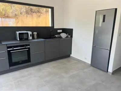 a kitchen with a microwave and a refrigerator at LOCA VACANCES in Porticcio