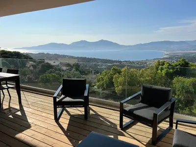 two chairs and a table on a deck with a view at LOCA VACANCES in Porticcio