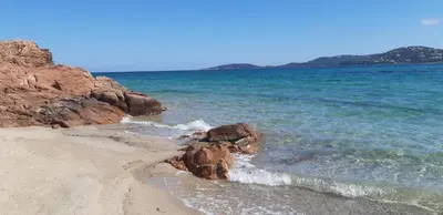 a beach with some rocks and the ocean at Appartement T2 en Corse dans résidence avec piscines proche de Porto Vecchio in Lecci