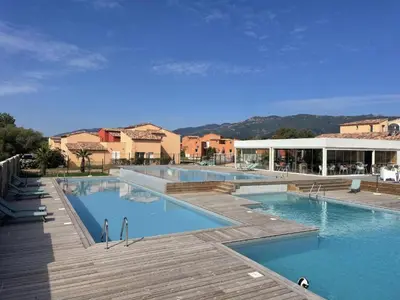 a large swimming pool with blue water in a resort at Appartement T2 en Corse dans résidence avec piscines proche de Porto Vecchio in Lecci