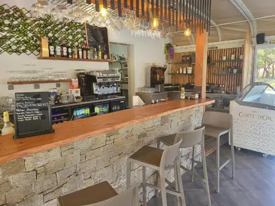 a bar in a restaurant with chairs and a counter at Appartement T2 en Corse dans résidence avec piscines proche de Porto Vecchio in Lecci