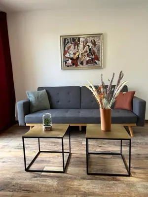 a living room with a blue couch and two tables at Très bel appartement à Ajaccio in Ajaccio