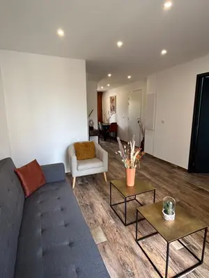a living room with a couch and two tables at Très bel appartement à Ajaccio in Ajaccio