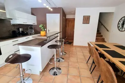 a kitchen with a counter and a table and chairs at Plage à pied : Mini villa Saint-Cyprien in Lecci