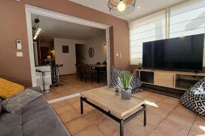 a living room with a couch and a large flat screen tv at Plage à pied : Mini villa Saint-Cyprien in Lecci