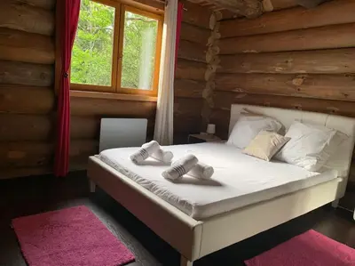 a bed in a log cabin with two towels on it at Hébergement d'exception à Zonza in Zonza