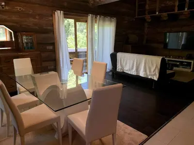 a dining room with a glass table and white chairs at Hébergement d'exception à Zonza in Zonza