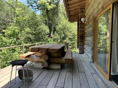a wooden porch with a picnic table on a deck at Hébergement d'exception à Zonza in Zonza