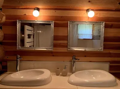 a bathroom with two sinks and two mirrors at Hébergement d'exception à Zonza in Zonza