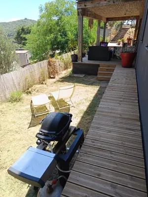a grill on a wooden walkway next to a patio at T3 en rez de villa sur les hauteurs d'Ajaccio in Ajaccio