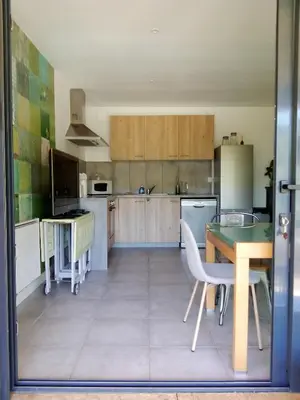 a kitchen with a table and a dining room at T3 en rez de villa sur les hauteurs d'Ajaccio in Ajaccio