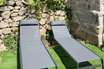 two benches sitting in front of a stone wall at Casetta Tozza Di Conca in Conca
