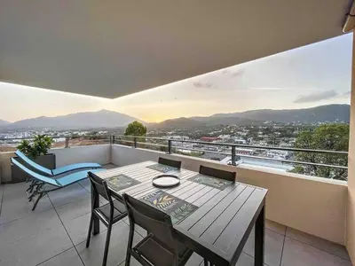 a balcony with a table and chairs and a view at Appartement central avec très jolie vue in Ajaccio