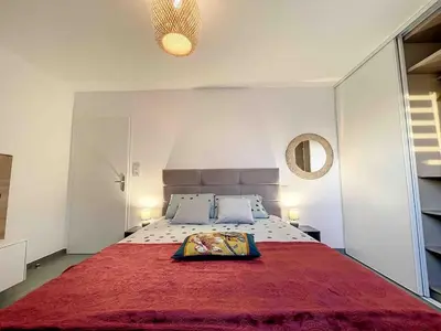 a bedroom with a large bed with a red blanket at Appartement central avec très jolie vue in Ajaccio