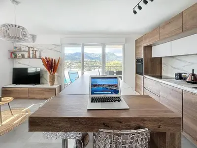 a laptop sitting on a wooden table in a kitchen at Appartement central avec très jolie vue in Ajaccio