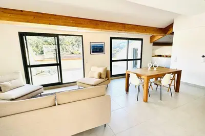 a living room with a couch and a table and chairs at Sur le port, 150m2 - Parking gratuit, Climatisation, Terrasses - Standing in Bonifacio