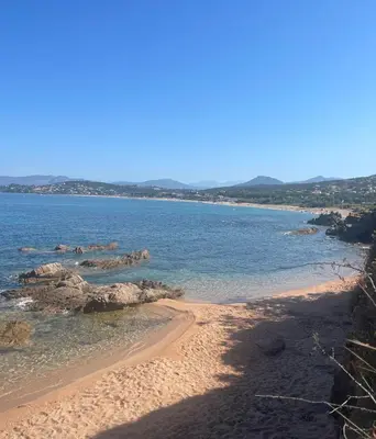 a beach with rocks and the ocean on a sunny day at mare noi in Pietrosella
