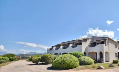 a white building with bushes in front of it at mare noi in Pietrosella