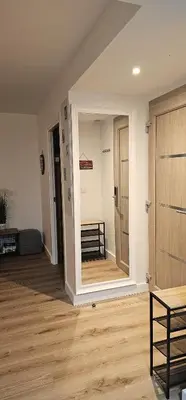 a room with a hallway with a door and a wooden floor at Fiori Di Cala Rossa Appartement T3 dans résidence hôtellière chez Virginie in Lecci