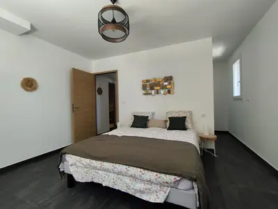 a bedroom with a large bed in a white room at Farniente e Dolce vita in Olmeto