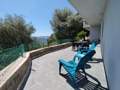 a balcony with two blue chairs and a table at Farniente e Dolce vita in Olmeto