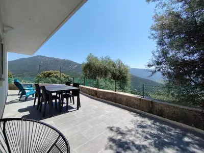 a table and chairs on a patio with a view at Farniente e Dolce vita in Olmeto