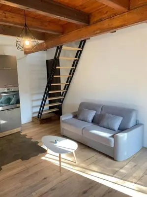 a living room with a couch and a table at Caseddu au coeur du village in Monacia-dʼAullène