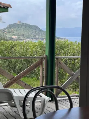 a table and chair on a porch with a view of the ocean at La vallée 2 in Belvédère