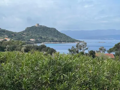 a hill with a house on top of it next to the ocean at La vallée 2 in Belvédère